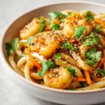 The delightful fusion of flavors in a Shrimp Fried Udon Bowl makes it a perfect dish for any occasion. This recipe brings together tender udon noodles and succulent shrimp with vibrant mixed vegetables, all tossed in a savory sauce that dances on the palate. The ingredients combine to create a delicious stir-fry that not only contains protein, carbs, and vegetables but also bursts with flavor. This dish is visually appealing, with its colorful array of vegetables and fresh herbs, making it a feast for the eyes as well as the taste buds.
