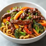 Spicy Beef and Black Pepper Udon Noodles is a delightful dish that brings together the hearty texture of udon noodles and the robust flavors of marinated beef. This recipe is quick to prepare, making it a perfect choice for weeknight dinners or when you're craving a flavorful yet simple meal. With juicy beef sirloin, vibrant vegetables, and a peppery kick, this dish is sure to impress both family and friends.