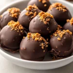Indulge your sweet tooth with these Decadent Peanut Butter Butterfinger Bliss Balls. Combining the rich, creamy flavor of peanut butter with the iconic crunch and sweetness of Butterfinger candy bars, these bliss balls are a true treat. Perfect for any celebration, whether it's a birthday party, holiday gathering, or just a special dessert night at home, these balls are sure to impress your friends and family with their delightful flavor and appealing look.
